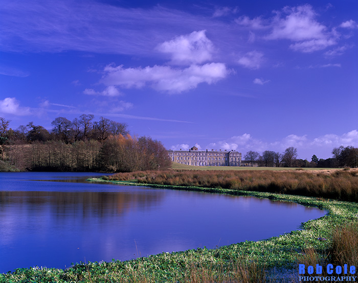 A view of Petworth House across the Upper Lake