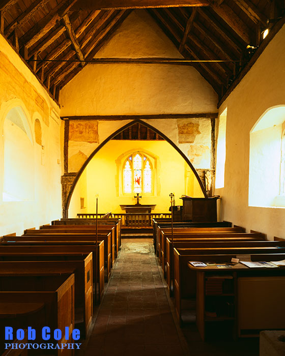 The interior of St Peters church, Southease bathed in a lemon yellow light