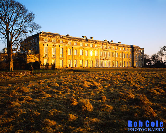 Low winter sun is reflected from the windows of Petworth House