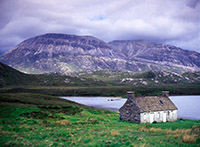 A disused bothy stands on the shore of Loch Stack