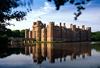 Herstmonceux Castle reflected in the moat on a summer afternoon