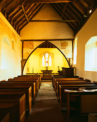The interior of St Peters church, Southease bathed in a lemon yellow light