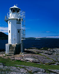 The lighthouse at Rubha Cadail stands on the rocky shore of Loch Broom near Rhue