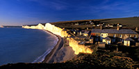Low winter sun illuminates the cliffs and cottages at Birling Gap